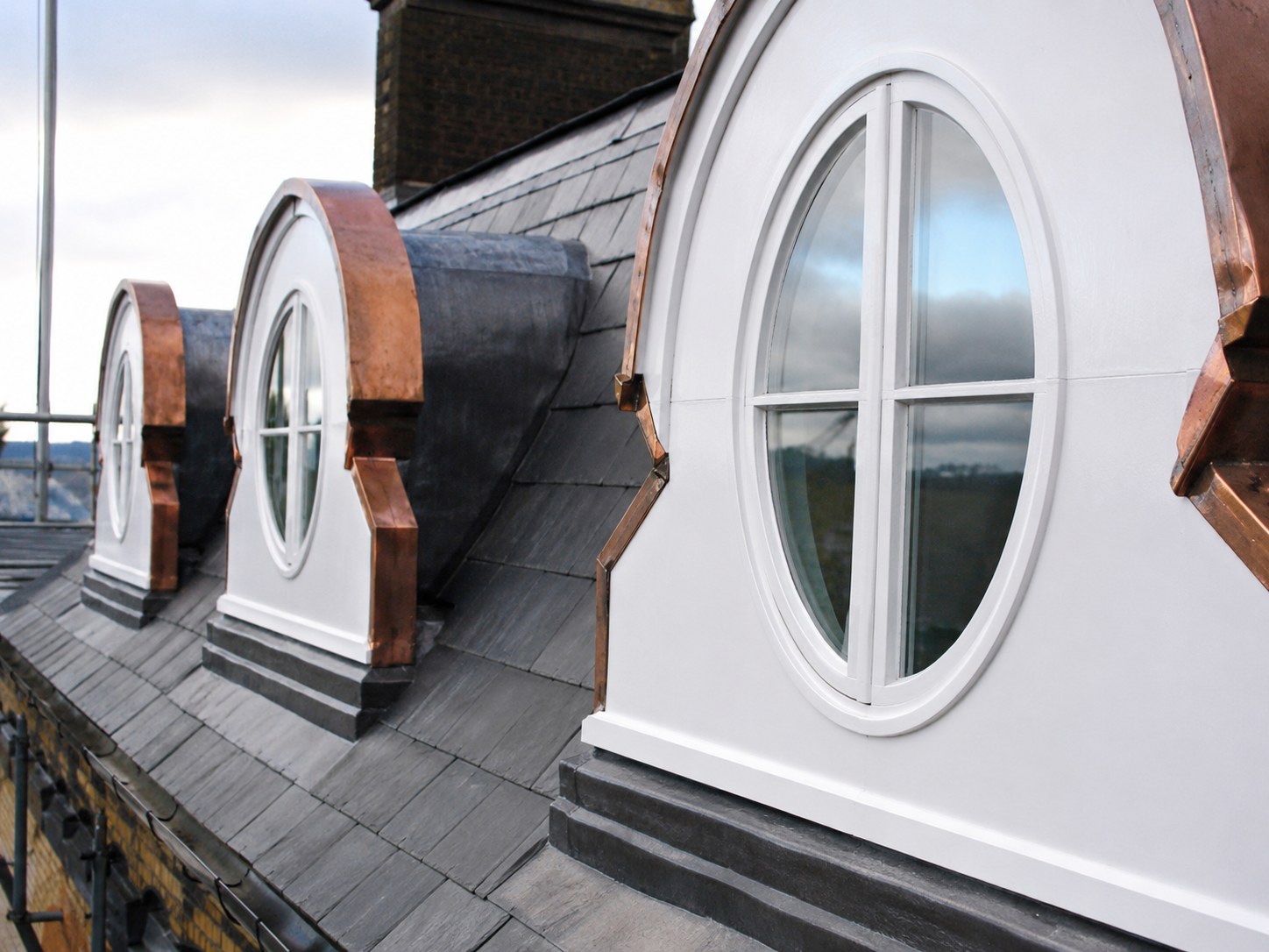 White circular dormer windows in a slate roof