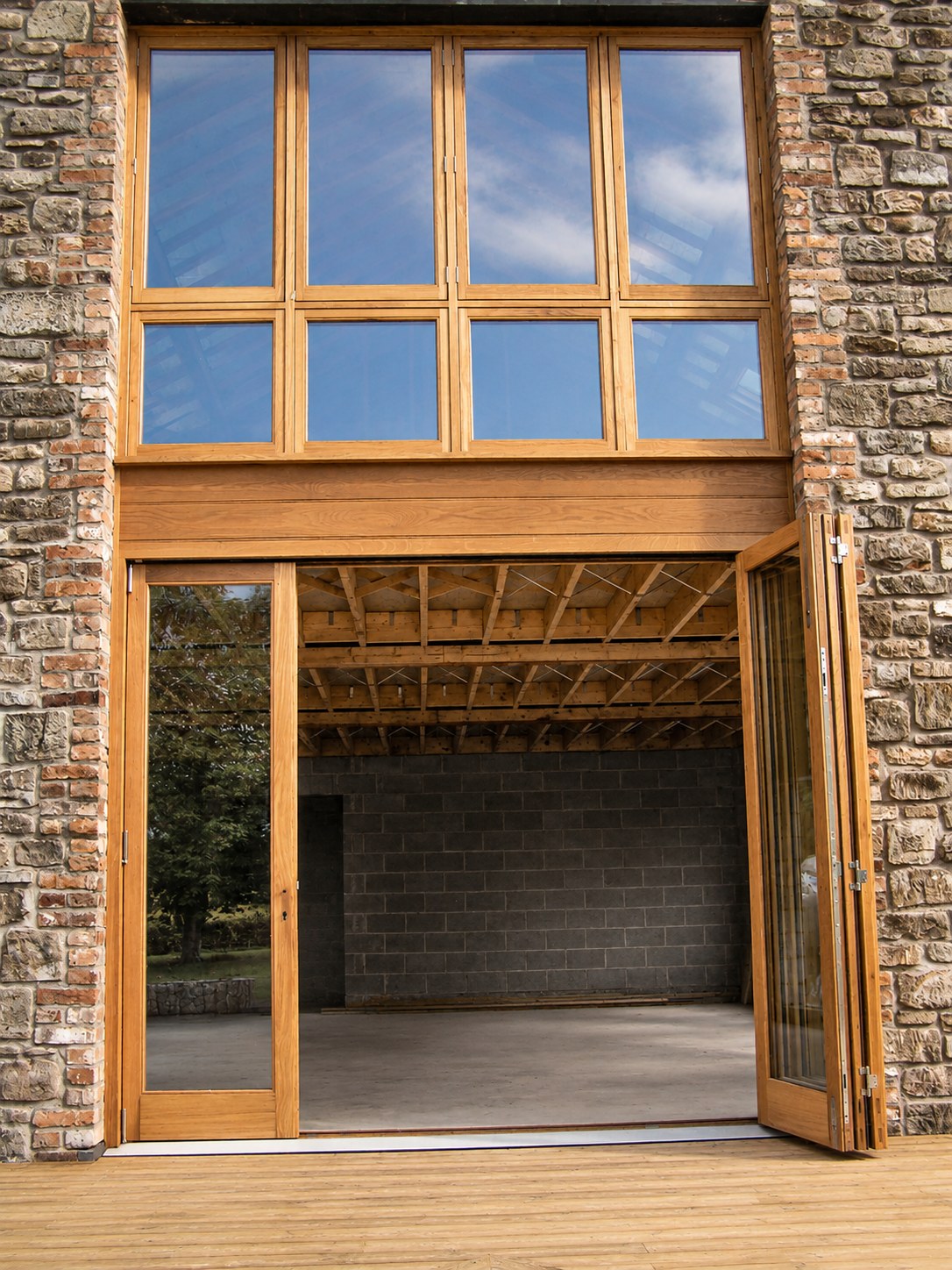 Tall timber screen and doors in a stone barn