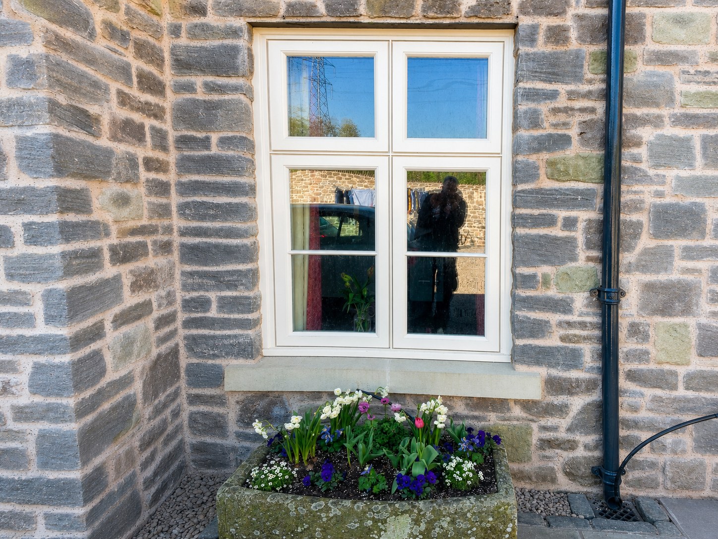 White casement window in a stone wall