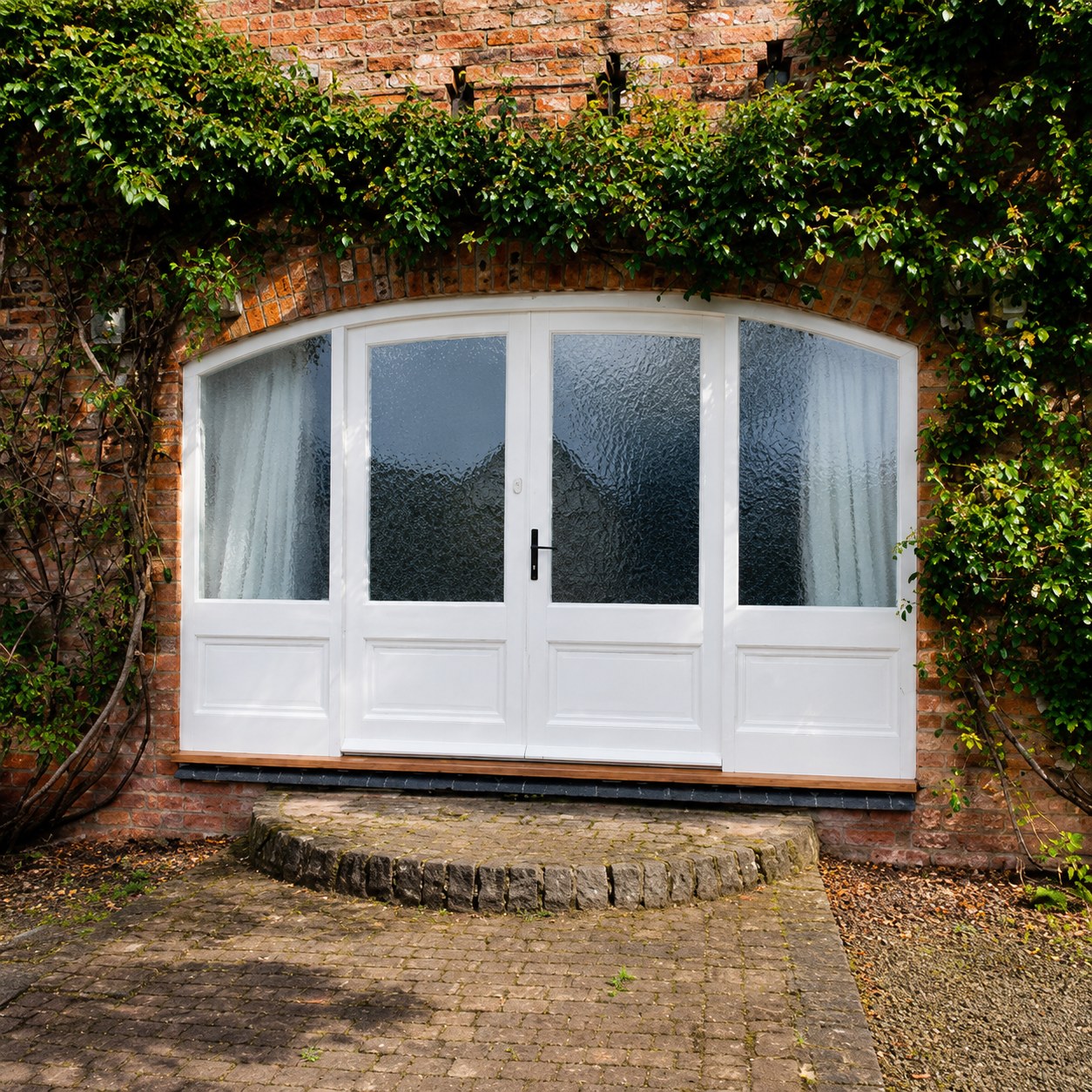 White glazed double doors below a curved lintel