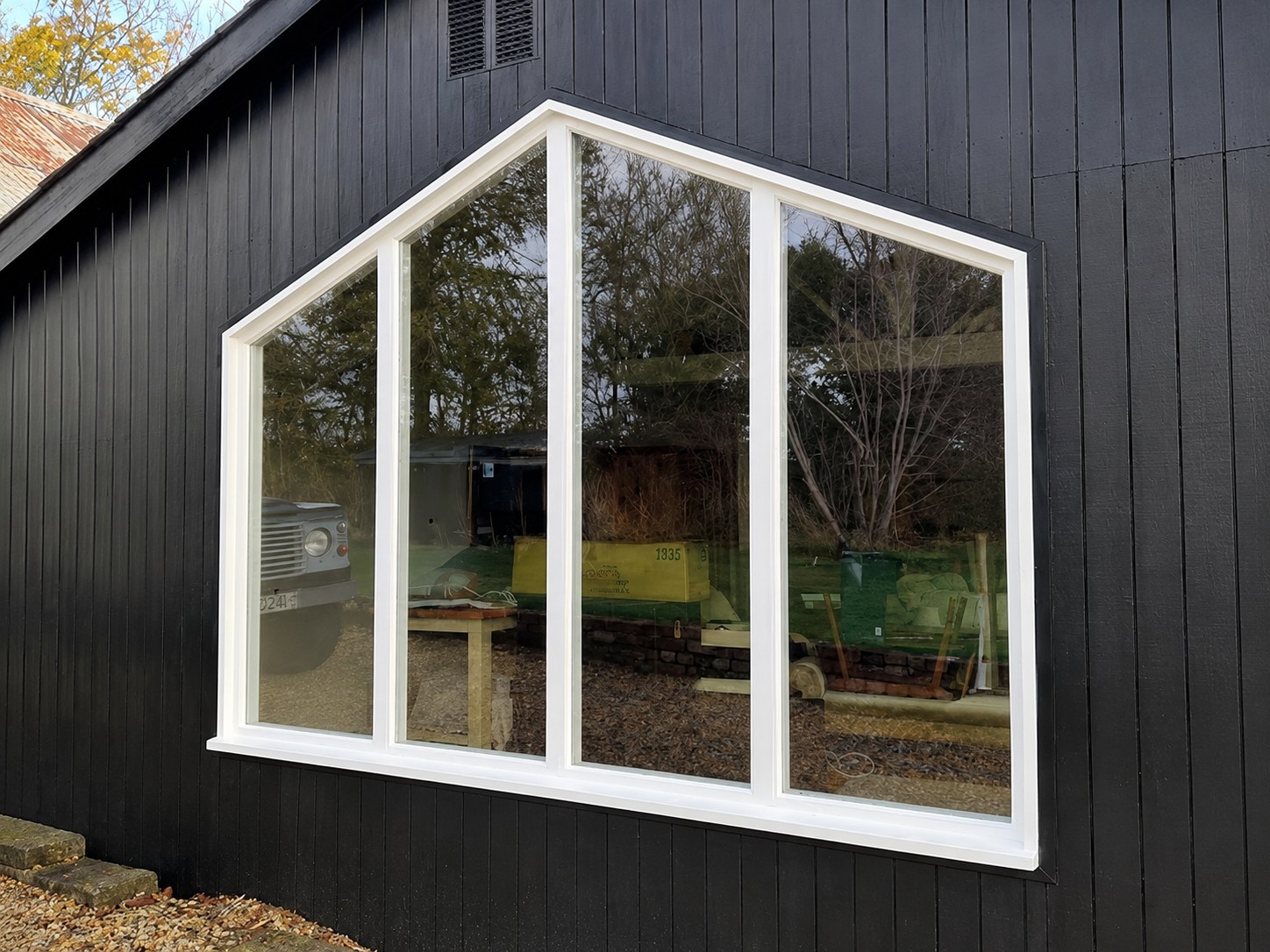 Gable-shaped window in dark vertical cladding