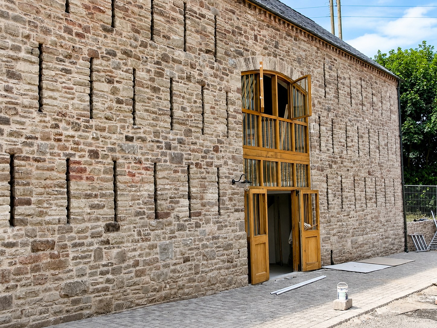 Large timber screen in a stone barn elevation
