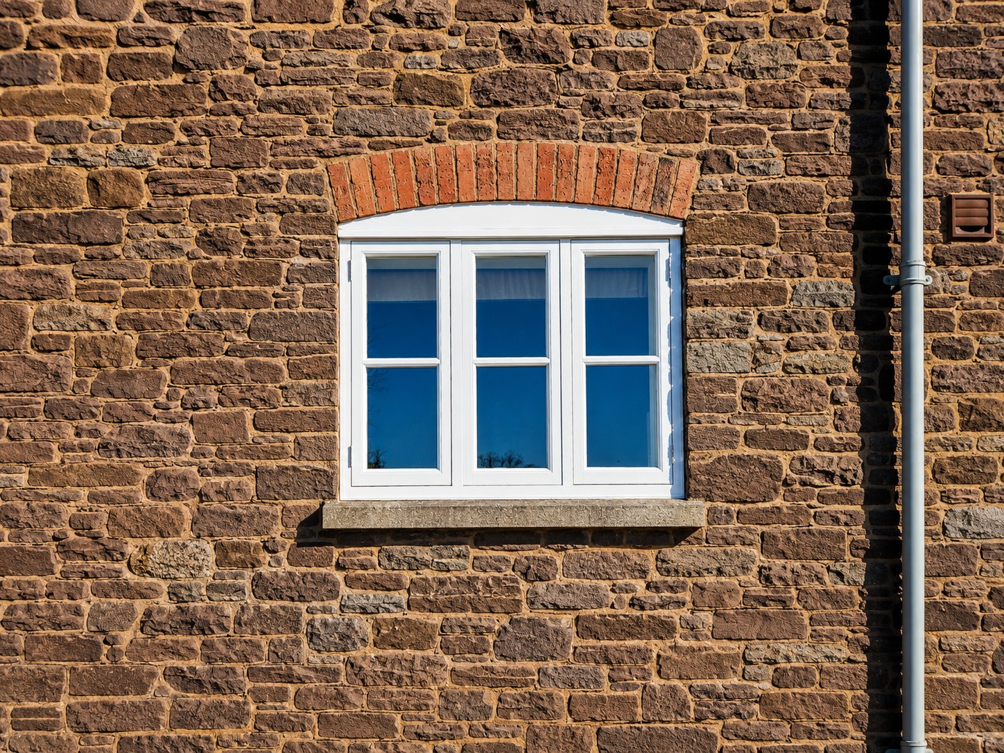 White multi-light casement window in stonework