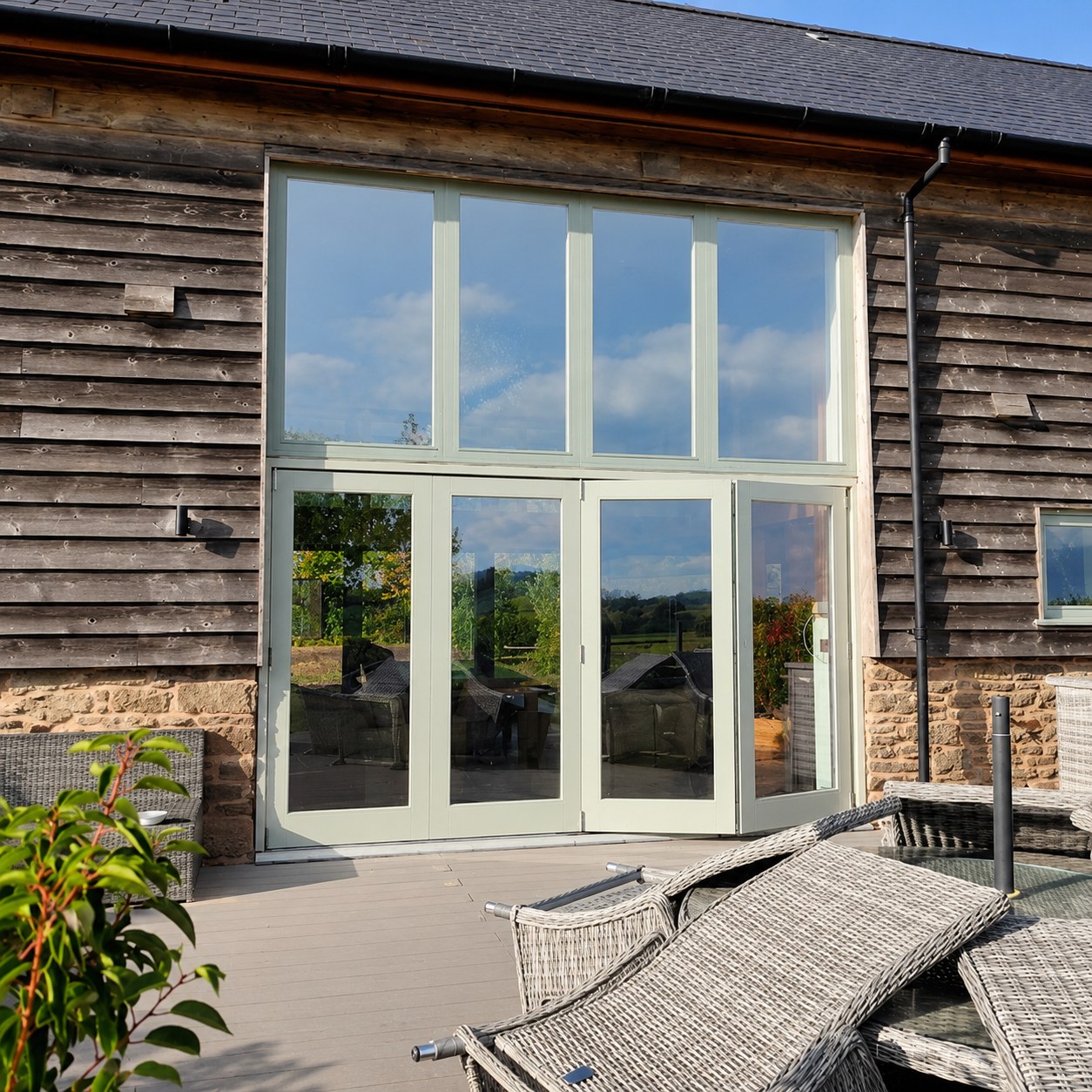 Tall painted glazing and doors in timber cladding