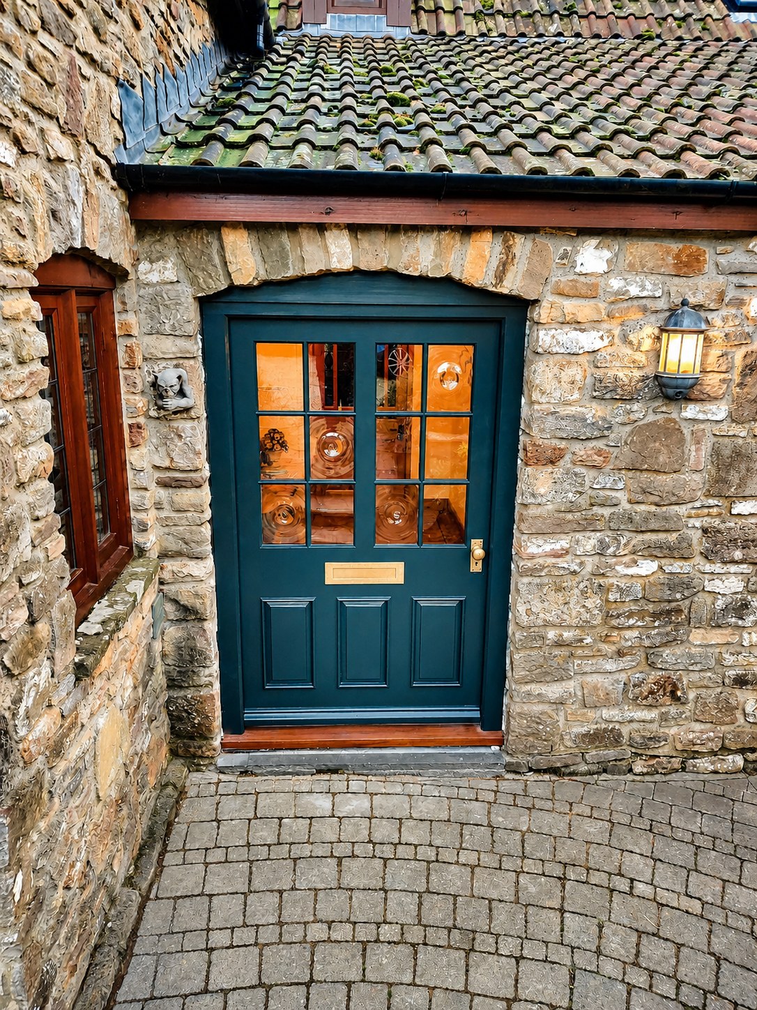Dark painted entrance door beneath a tiled canopy