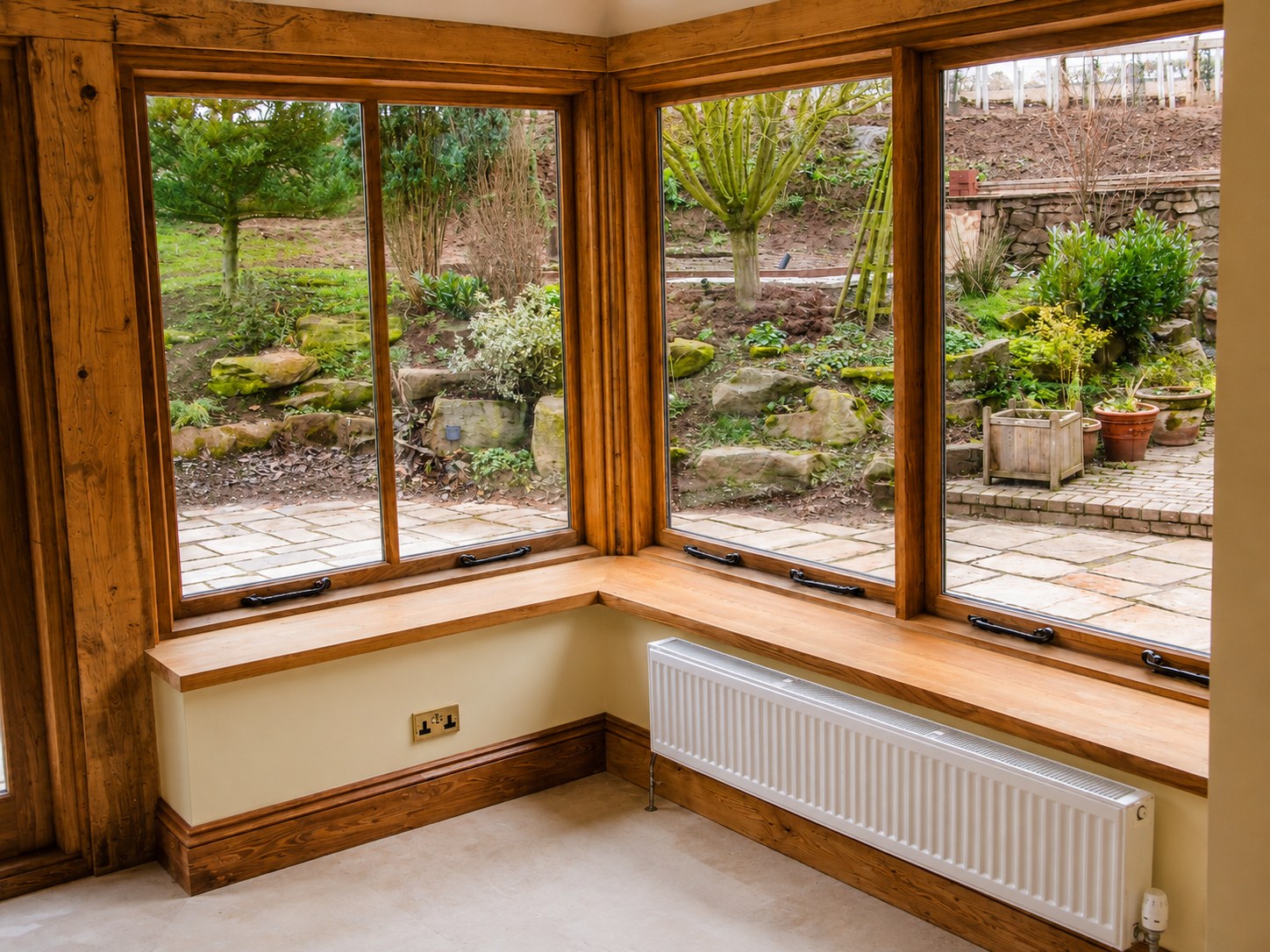 Garden-room corner with timber windows and window seats