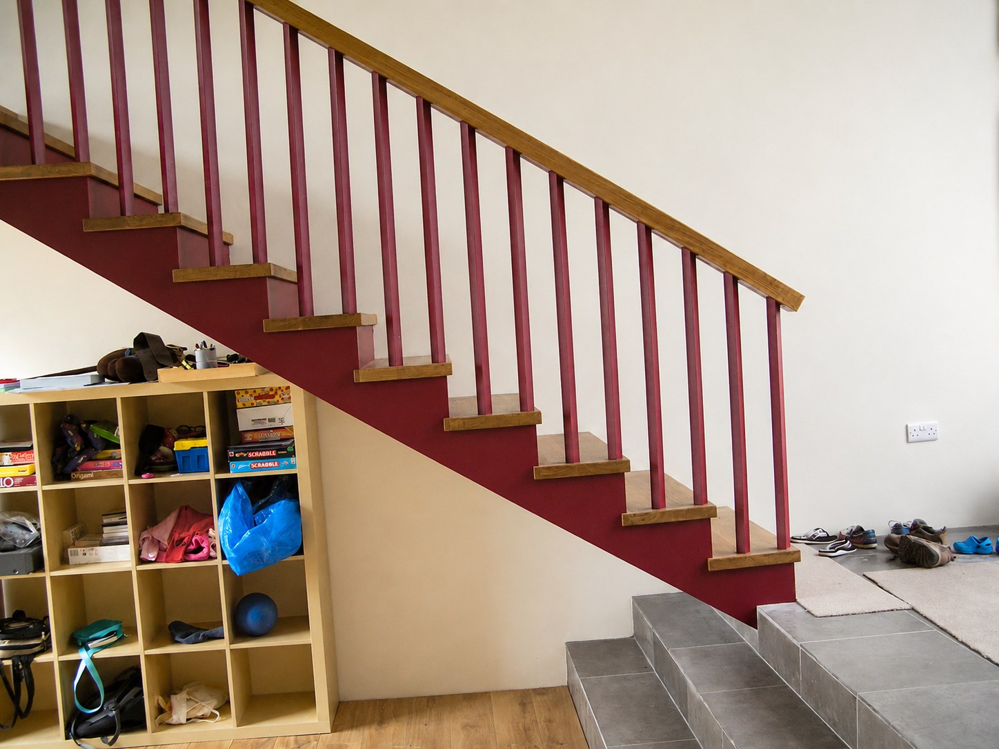 Straight timber staircase with red-painted balusters