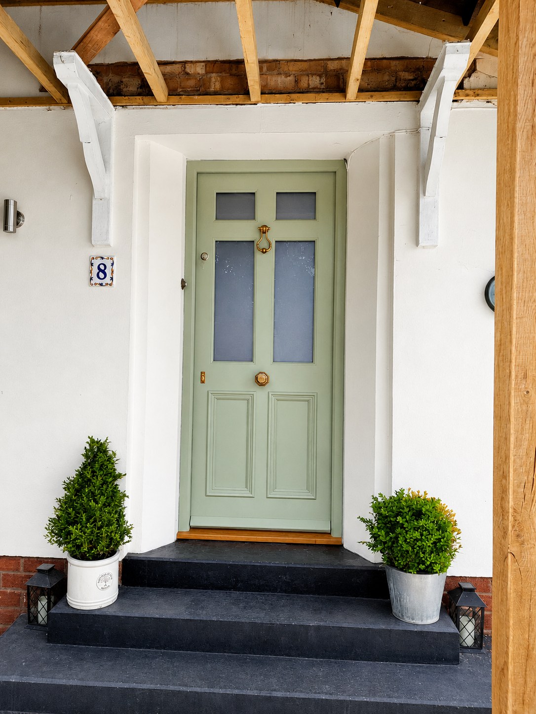 Pale painted entrance door beneath a porch