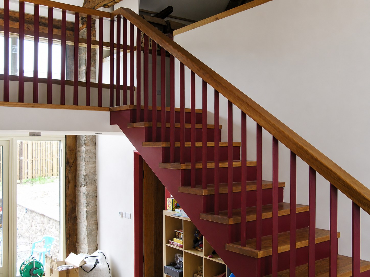 Timber staircase with red balusters and a turning flight