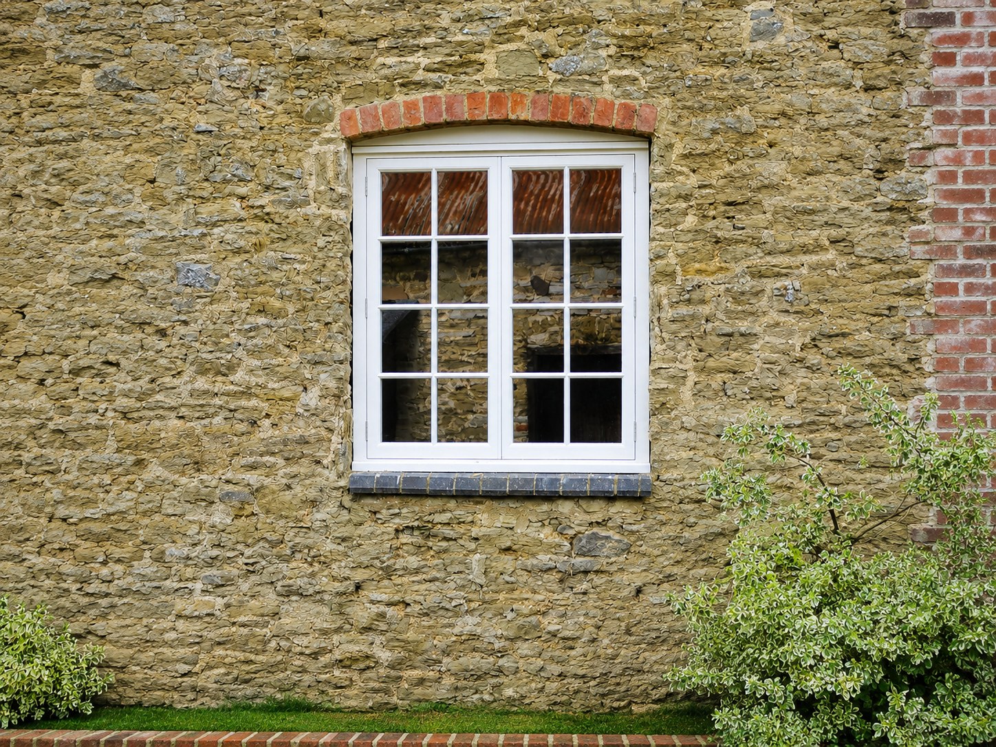 Divided-light painted window beneath a stone arch