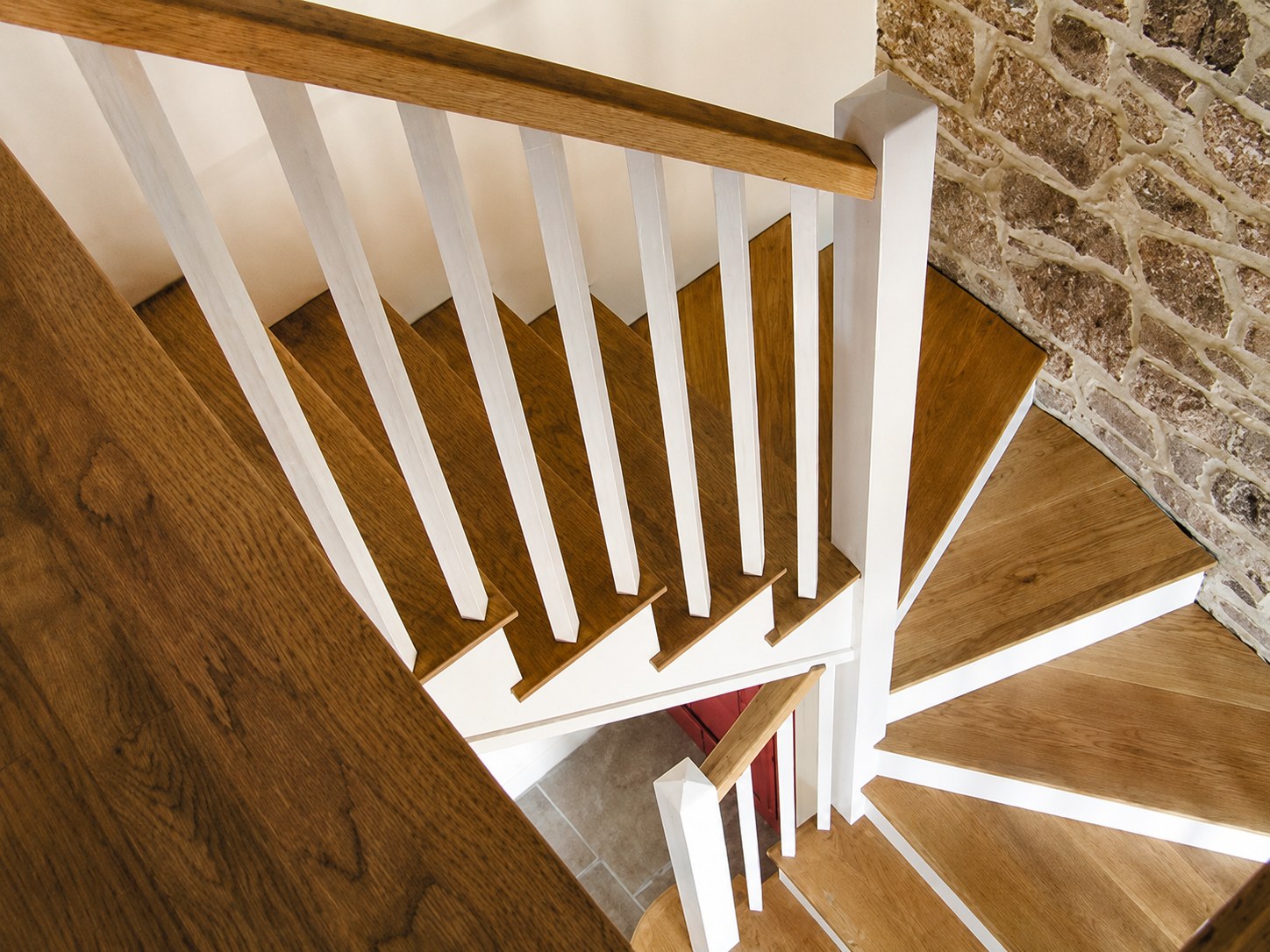Timber stair treads and white balusters beside stonework