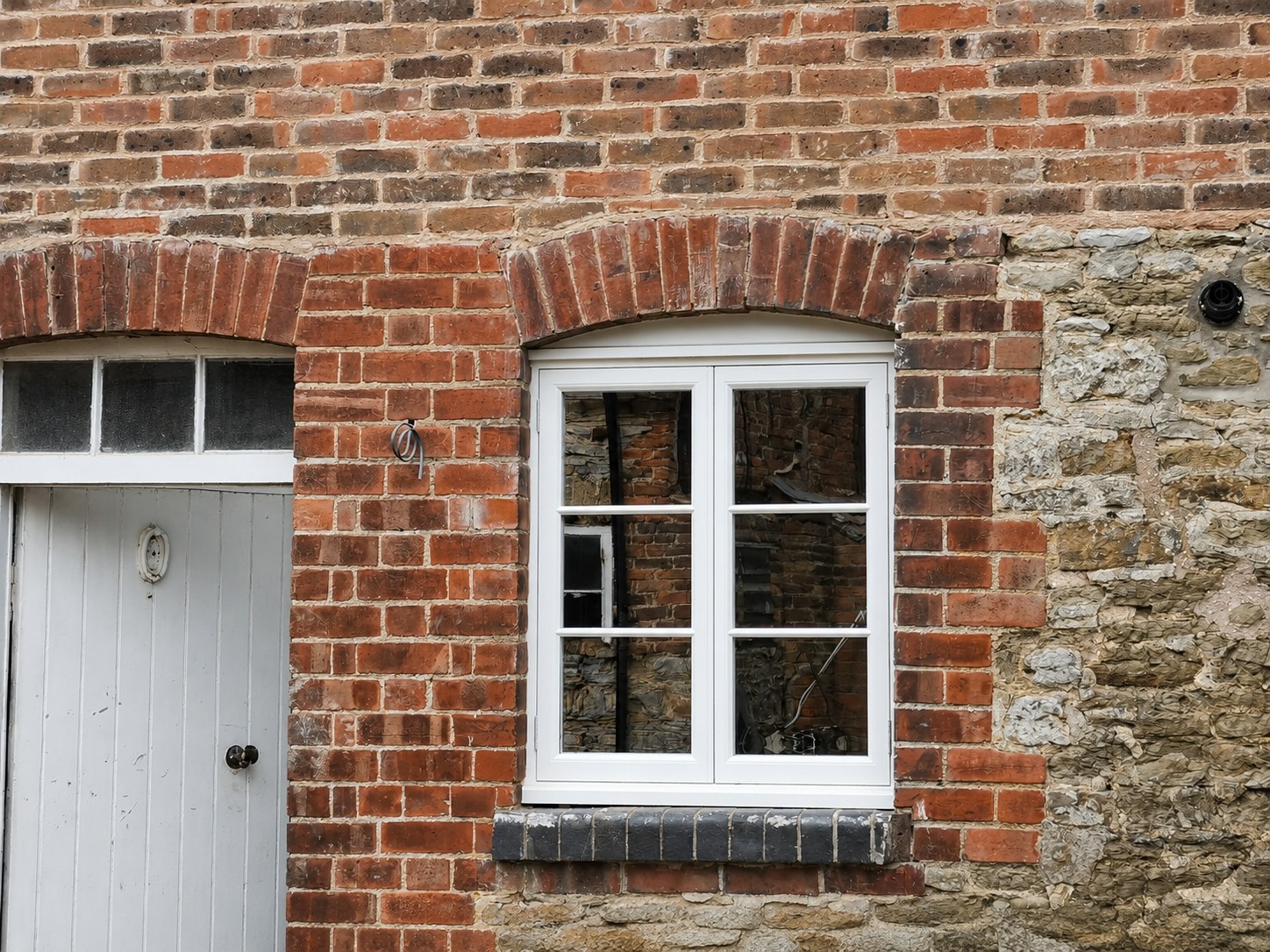 White divided-light window in a brick wall