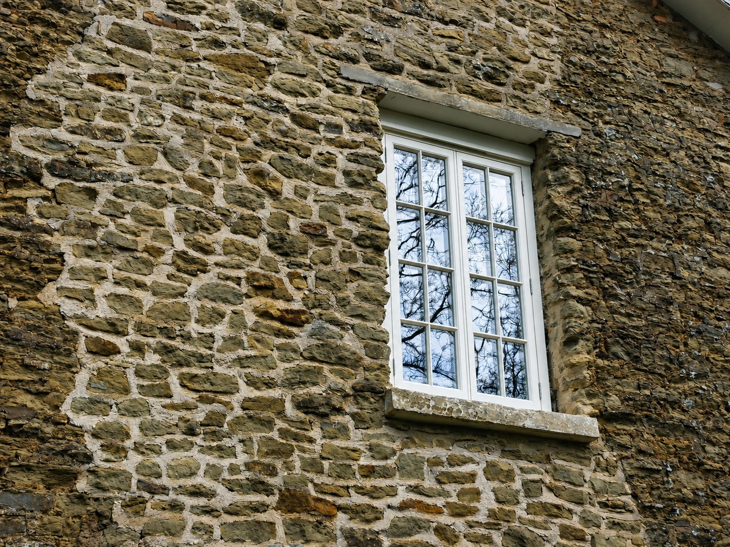 Tall divided-light window in a stone wall