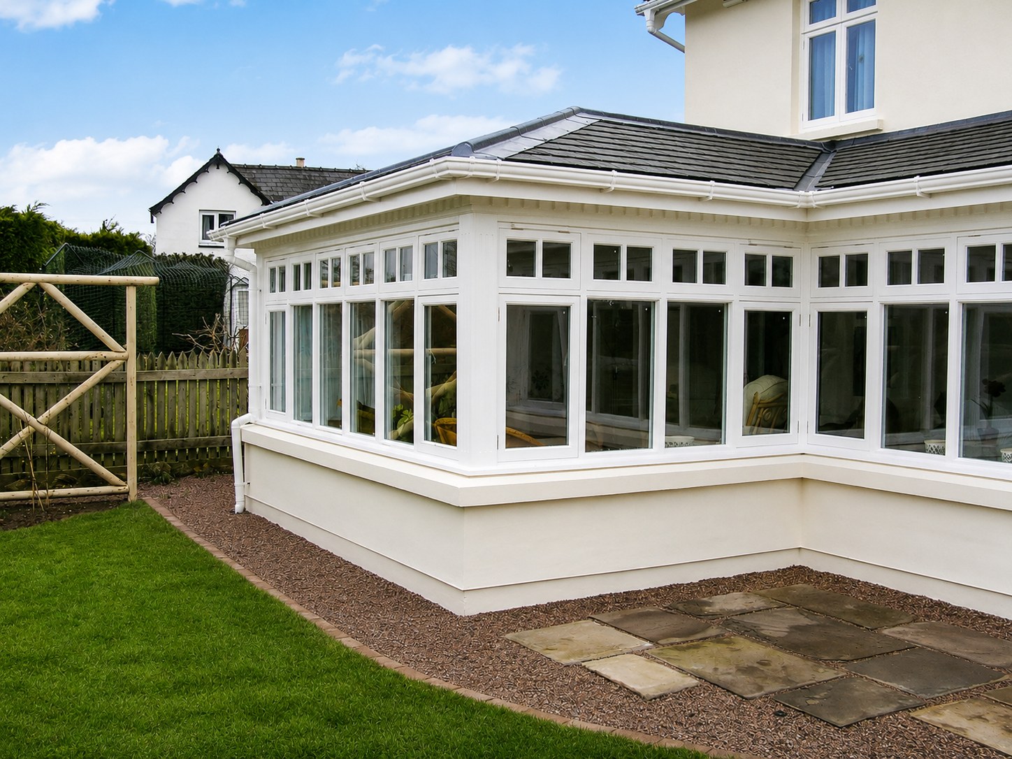 Painted conservatory and glazed doors facing a lawn