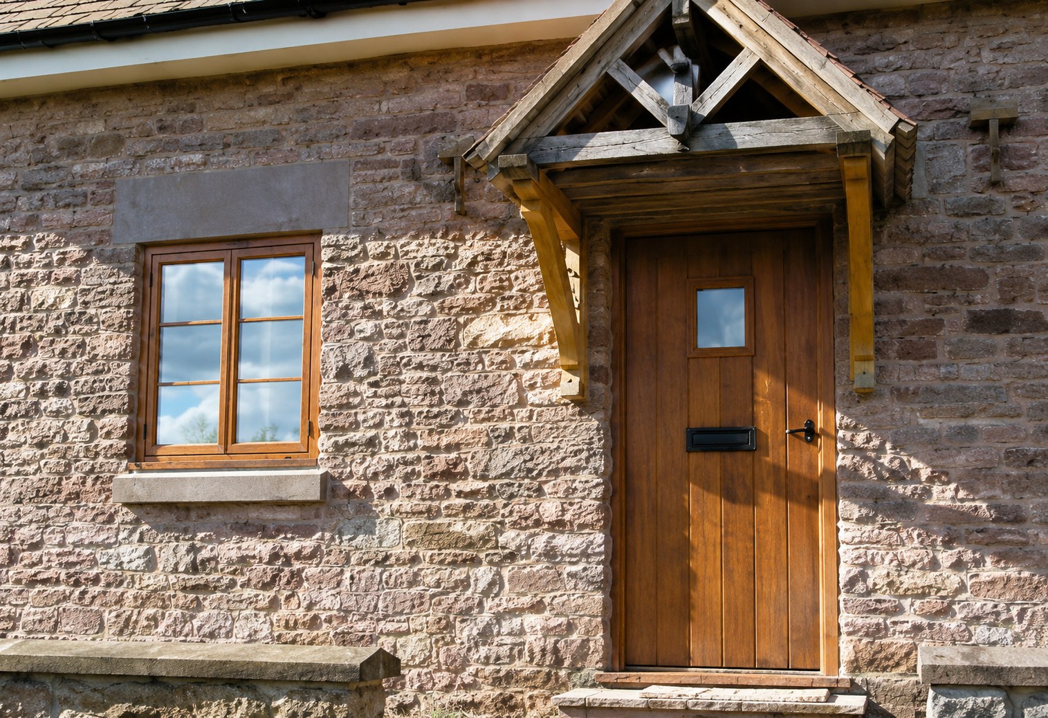 Timber entrance door beneath a pitched canopy