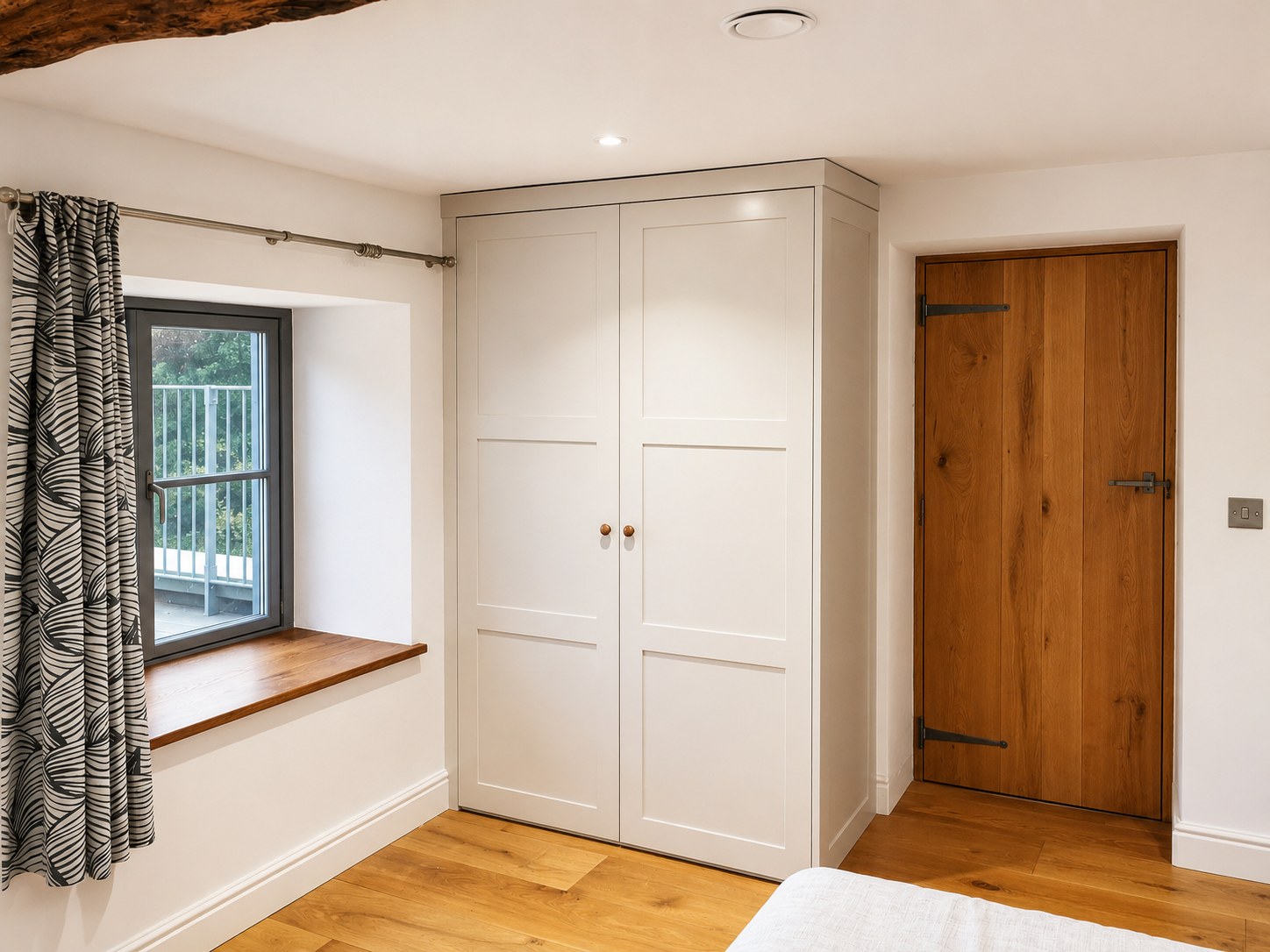 Painted fitted wardrobe beside a timber door