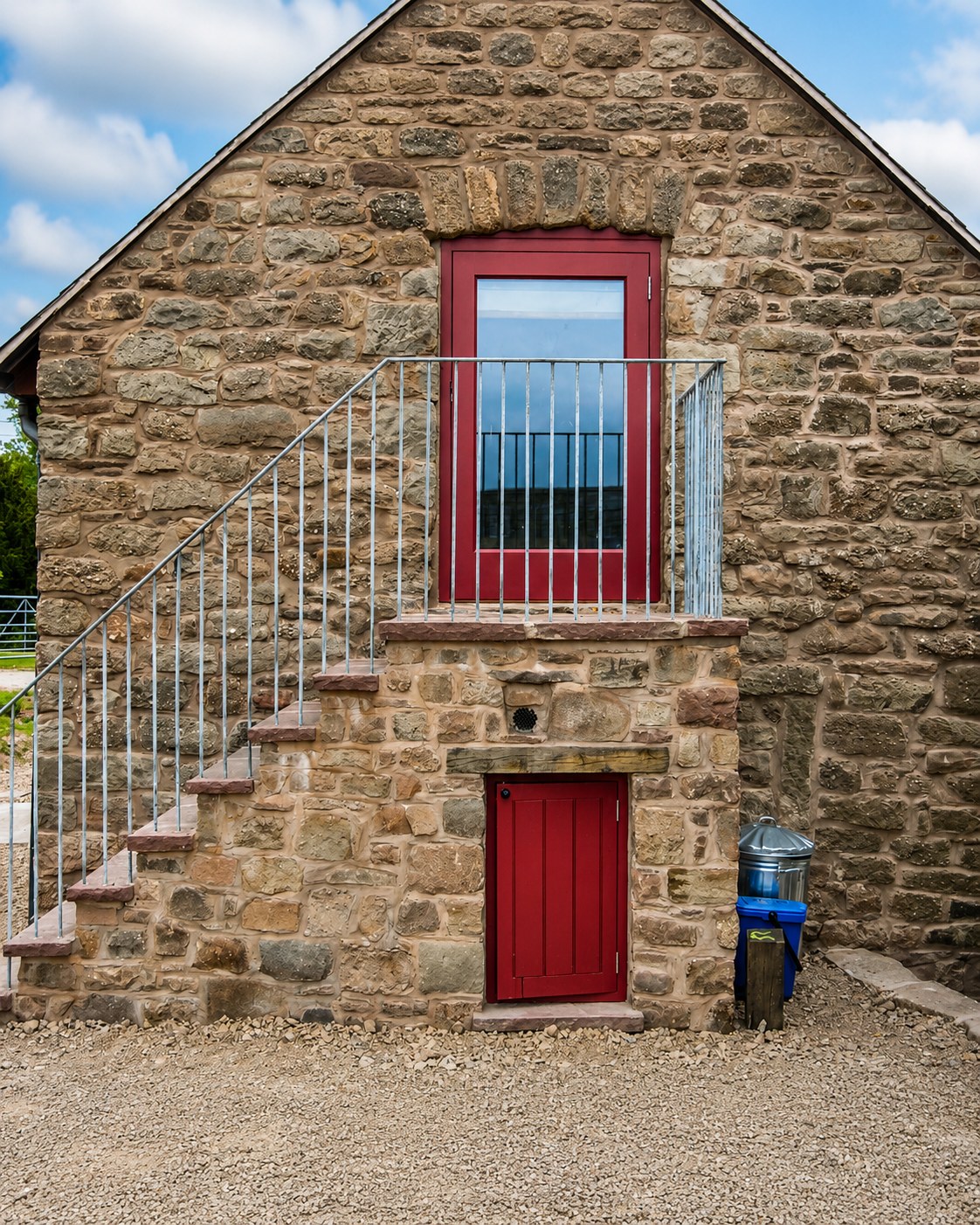 Red-painted opening and external stair on a stone building