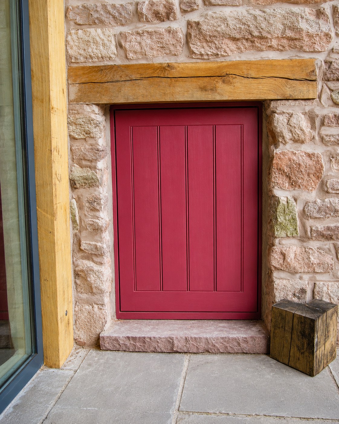 Red-painted boarded door in a stone outbuilding
