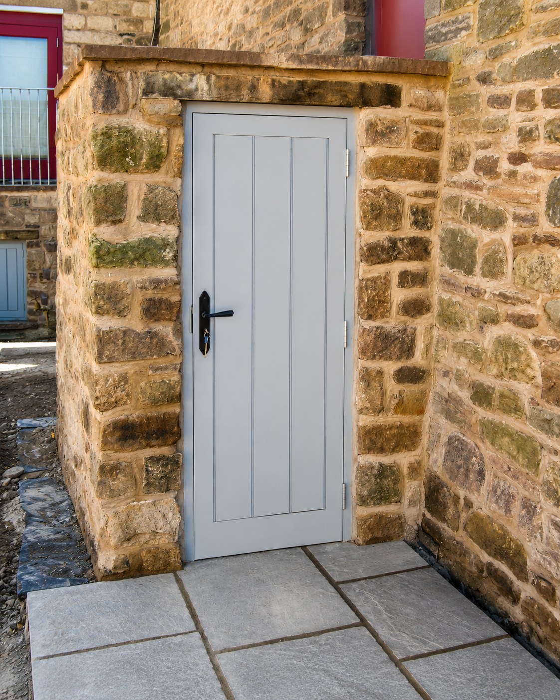 Grey-painted boarded door in a stone opening