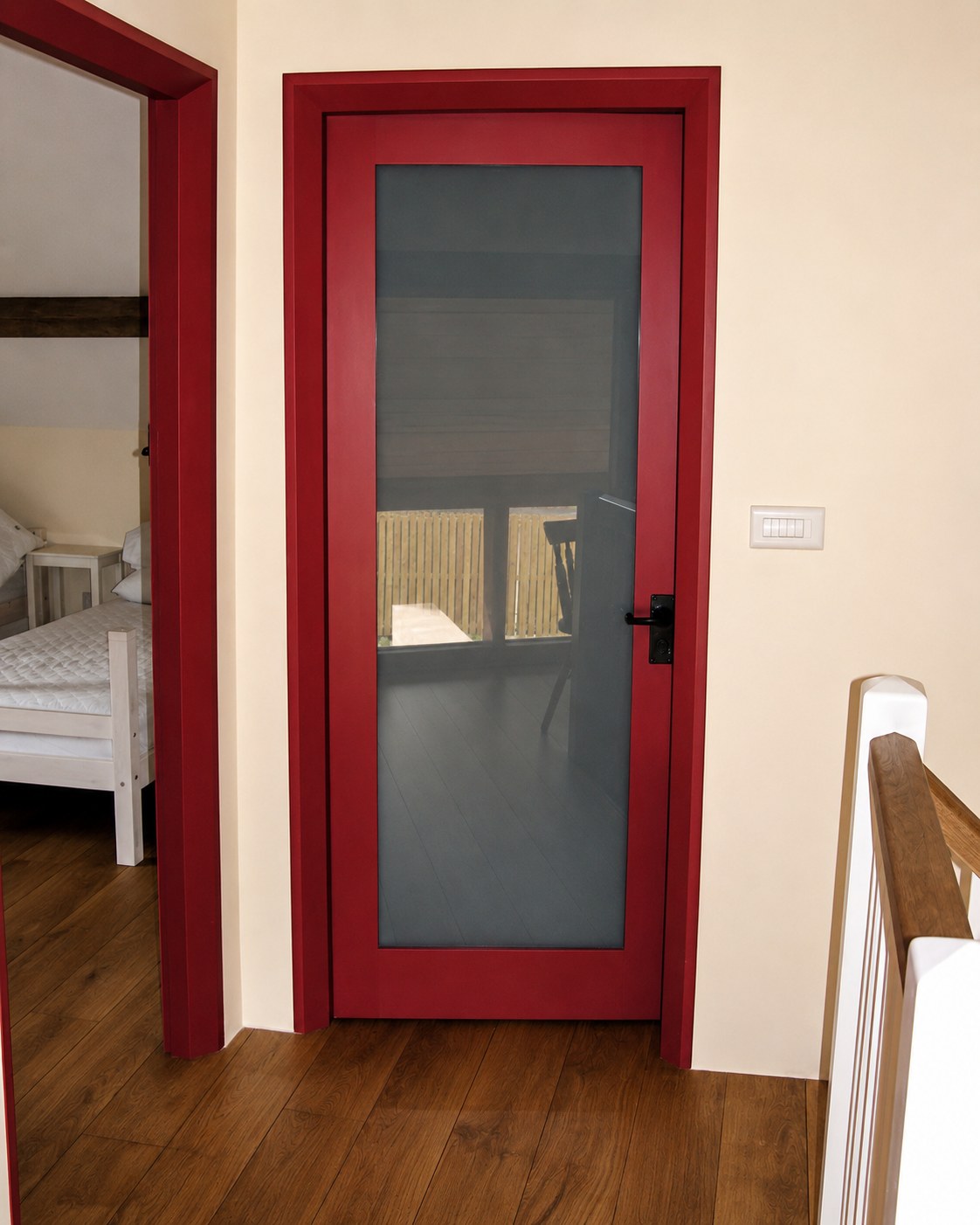 Red-painted internal door with a long glazed panel
