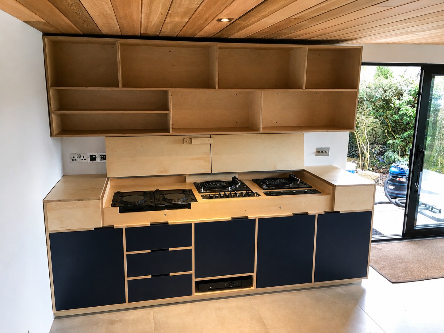 Dark kitchen base units and timber shelves during installation