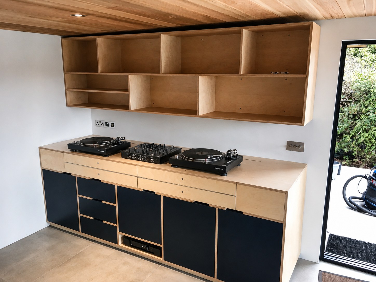 Kitchen cabinetry being fitted below open shelving