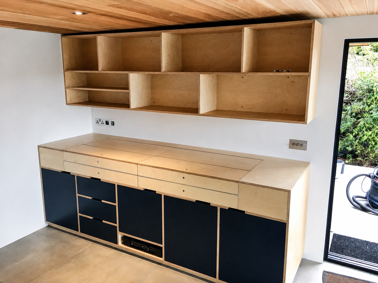 Kitchen base cupboards and timber wall shelves