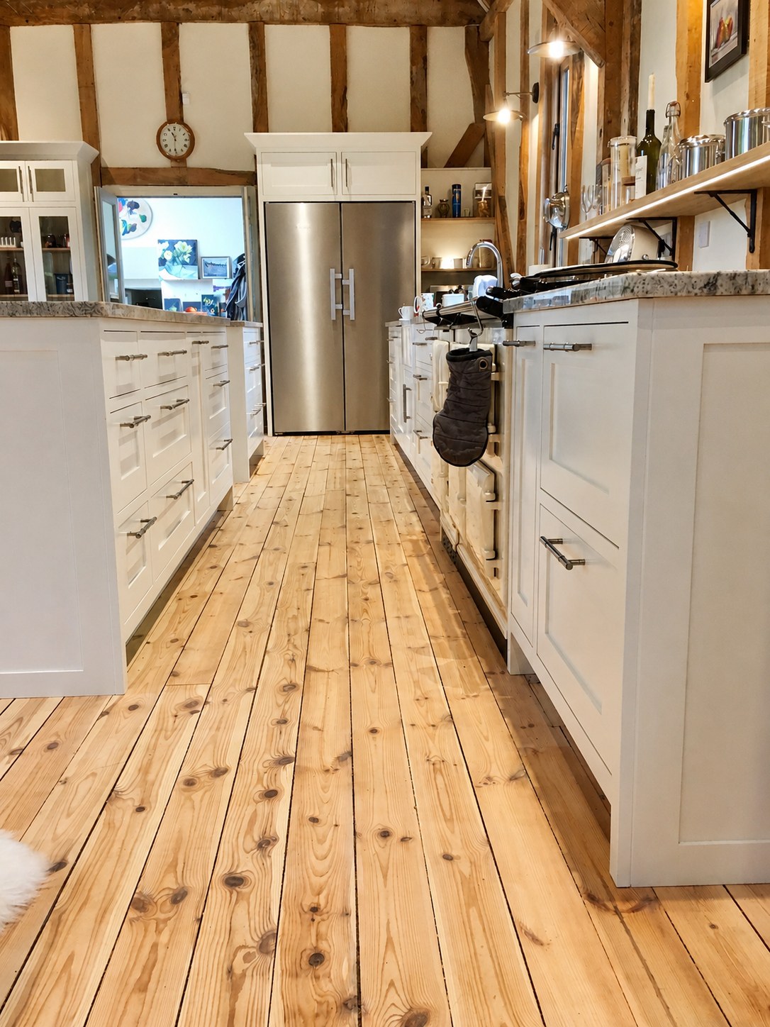 Kitchen cabinetry viewed along a timber floor