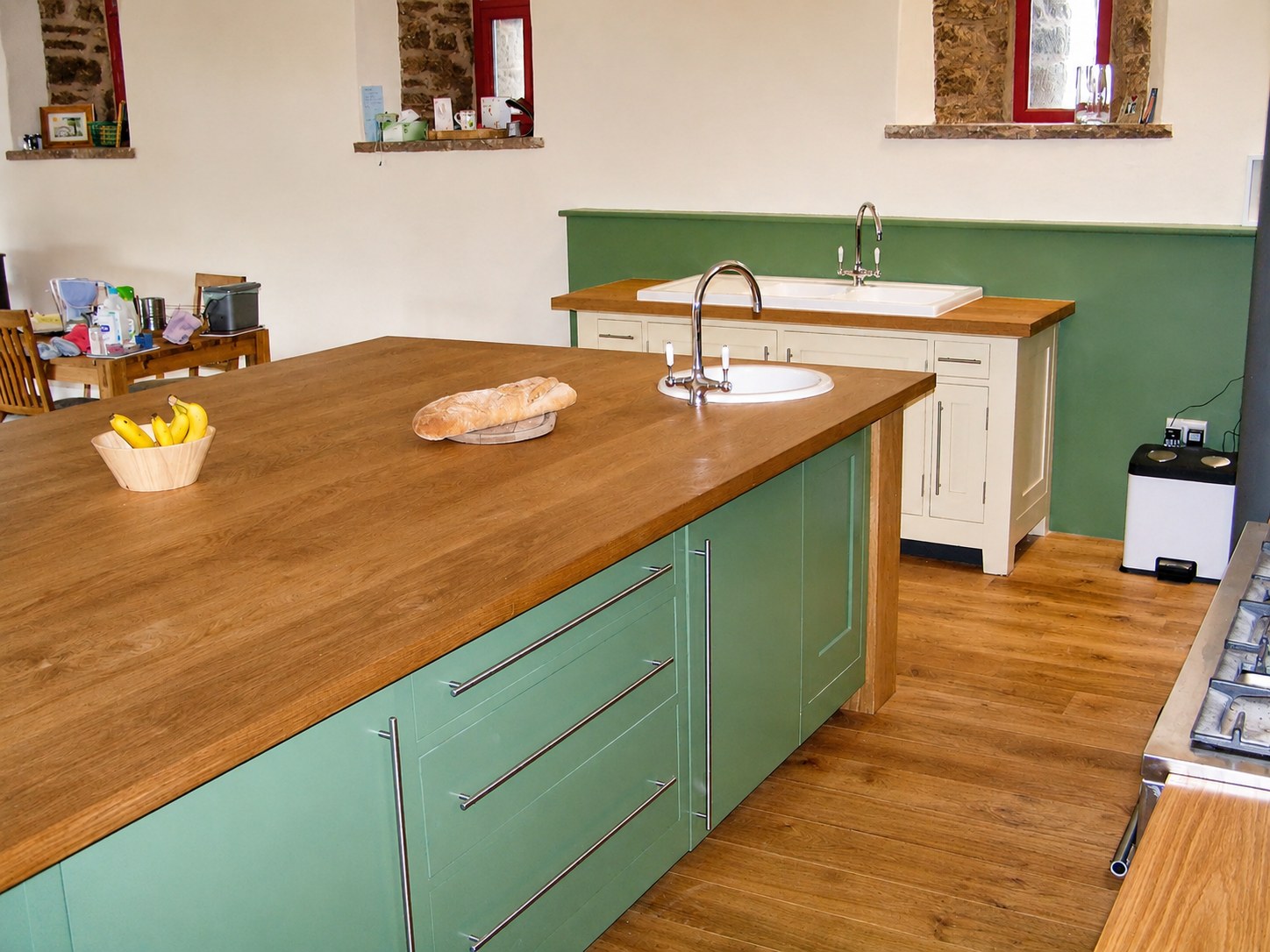 Green kitchen island and painted perimeter cabinets