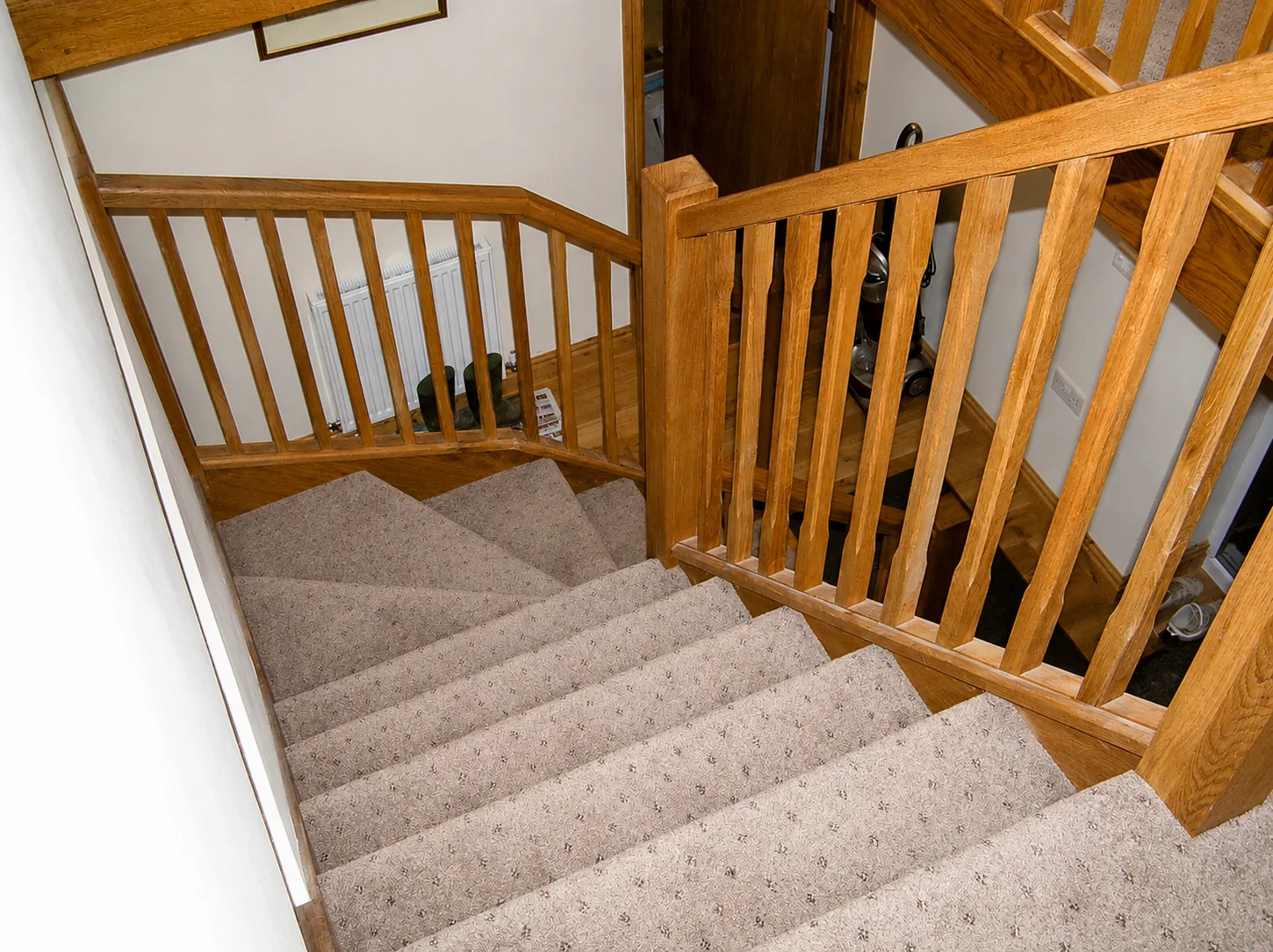 Carpeted stairs with timber handrail and balusters