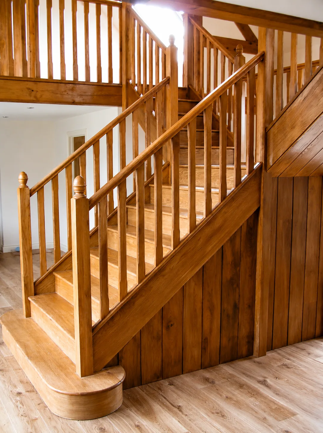 Timber staircase with shaped lower treads and a panelled enclosure