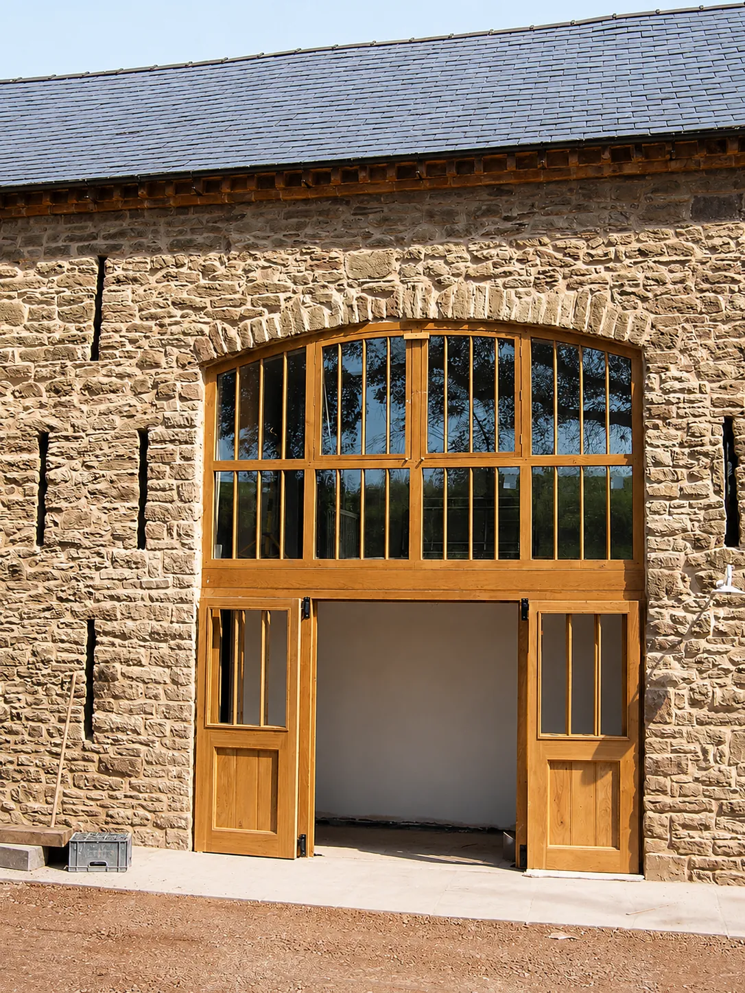 Arched timber screen and doorway in a stone barn