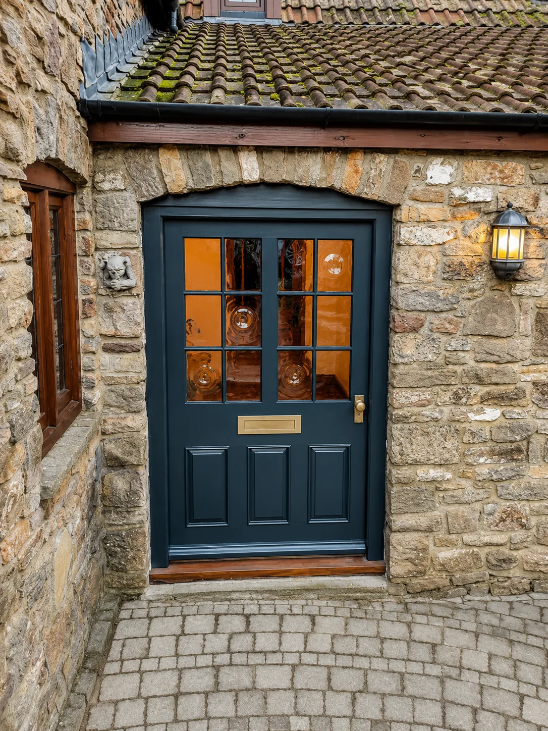 Dark painted entrance door with divided glazing and brass hardware