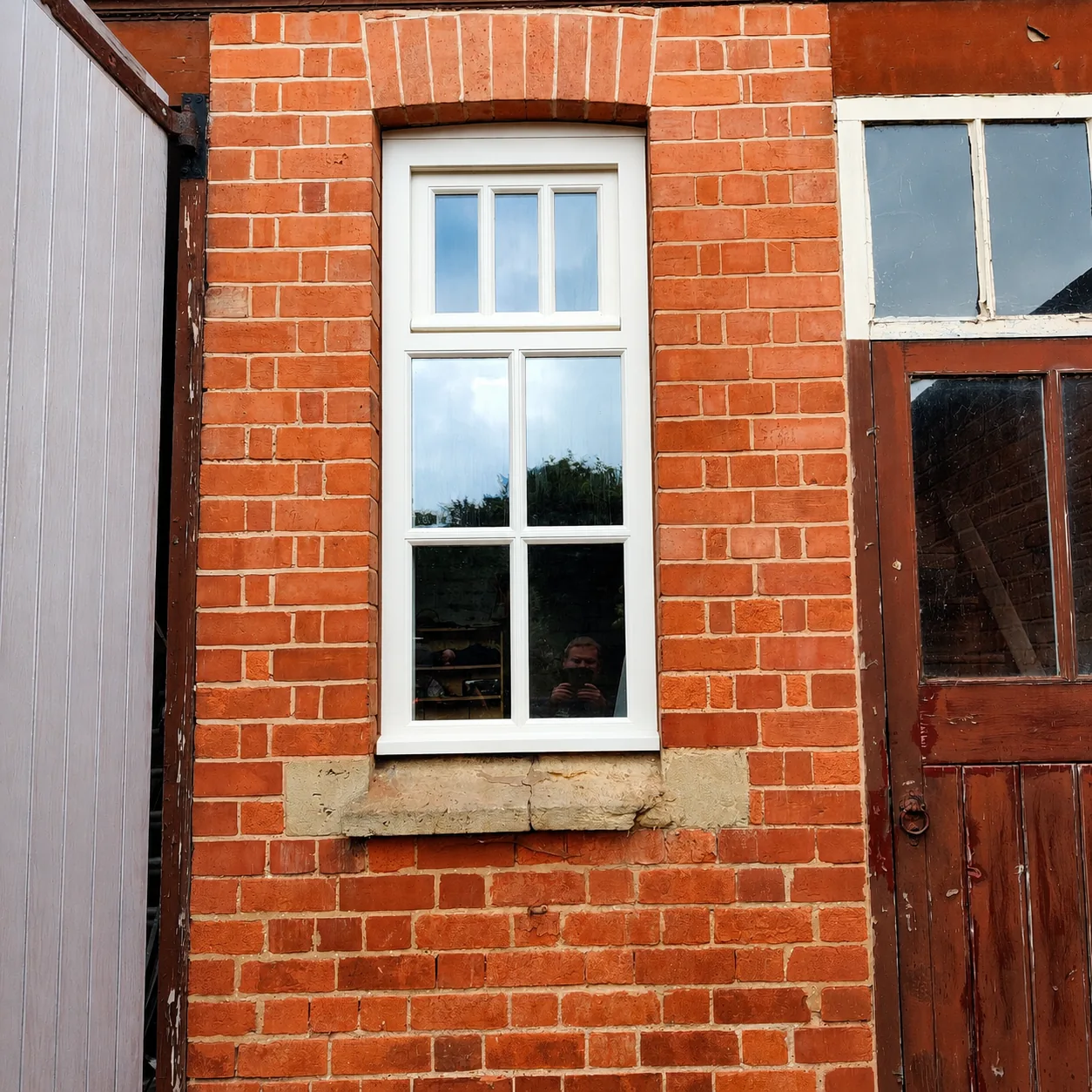 Painted timber window in brick