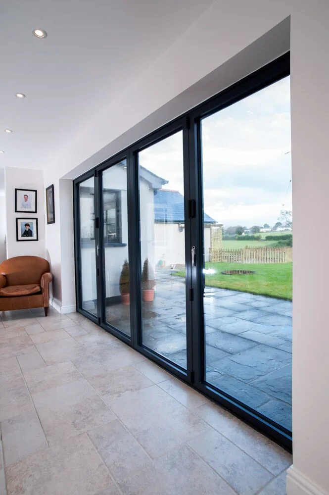 Aluminium folding doors viewed along a tiled room