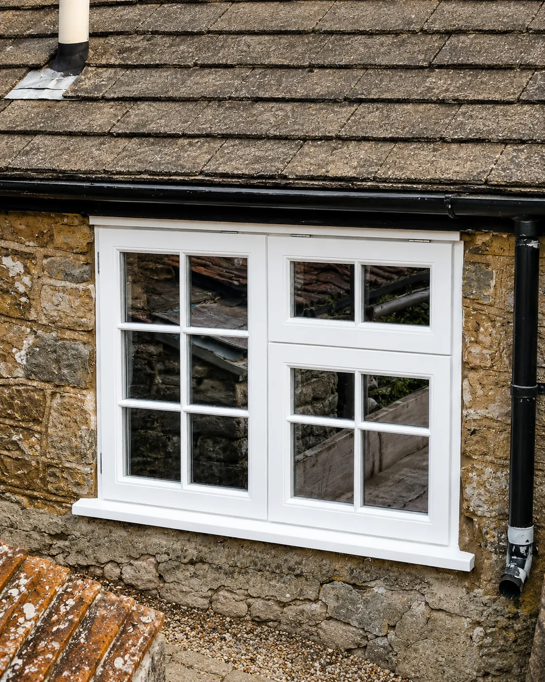 White painted casement window in a timber-clad wall