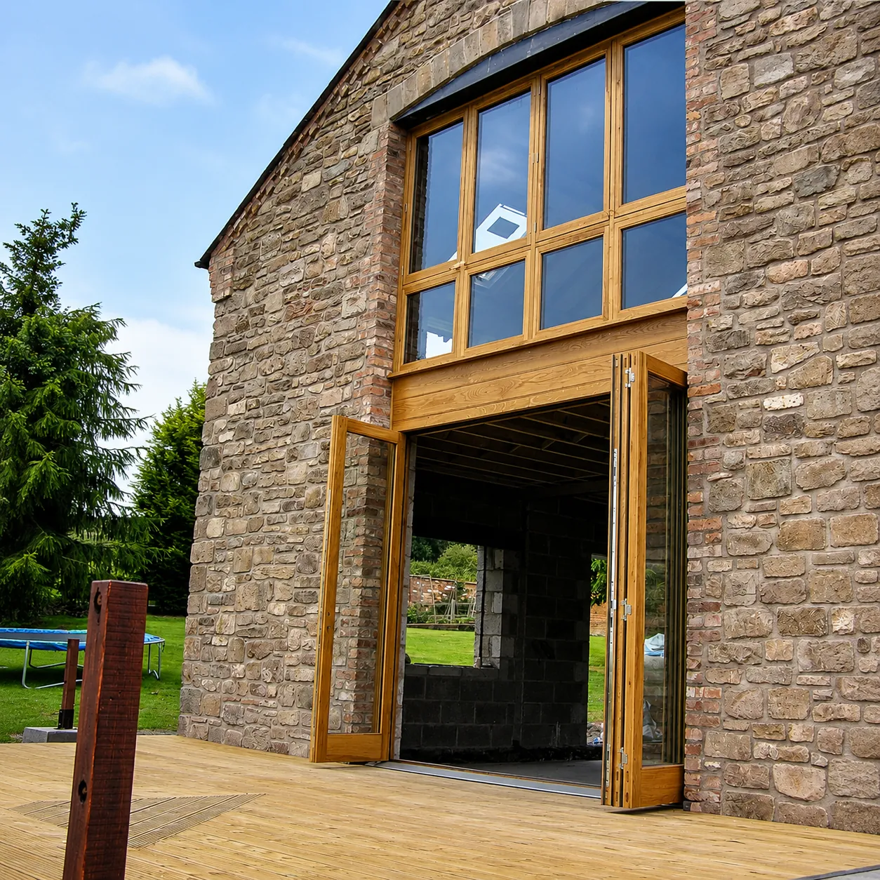 Timber glazed screen and double doors in a stone barn