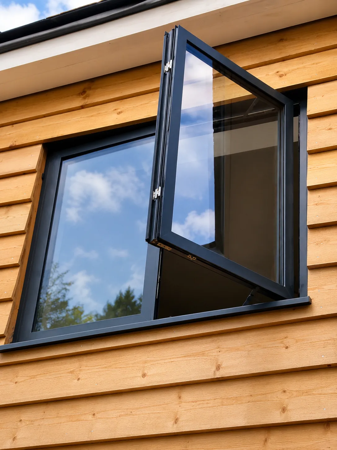 Open grey aluminium casement in timber cladding